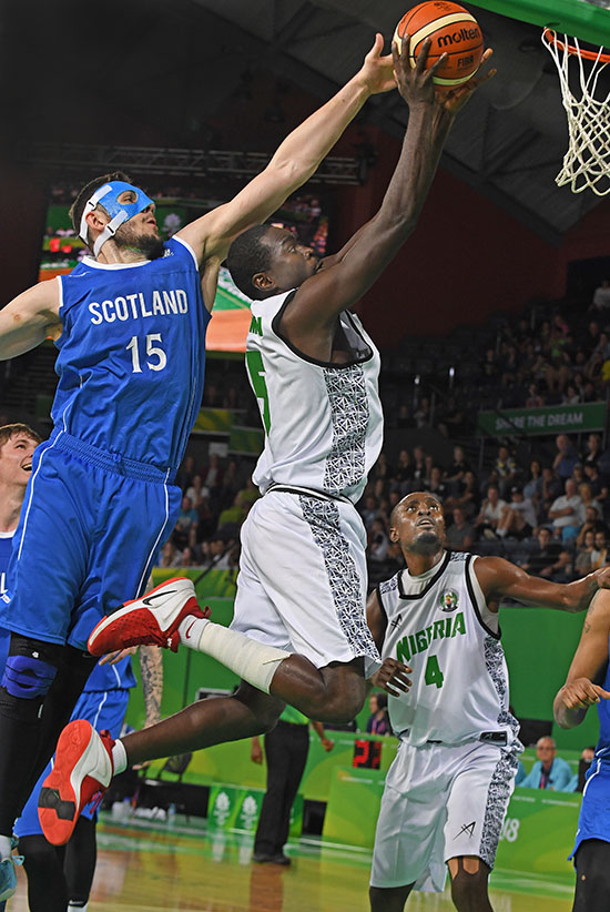 Nigeria's Musa Usman goes up to shoot as Scotland's Alasdair Fraser tries to block during the Men's Qualifying Finals basketball game between Scotland and Nigeria at the XXI Commonwealth Games in Cairns - image by Brian Cassey